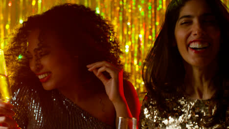 Close-Up-Of-Two-Women-Dancing-In-Nightclub-Bar-Or-Disco-Drinking-Alcohol-With-Sparkling-Lights-20